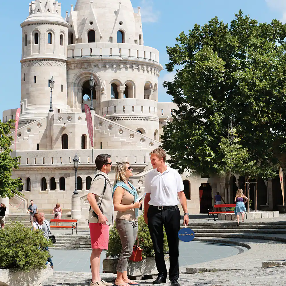 Three people standing in front of a castle.