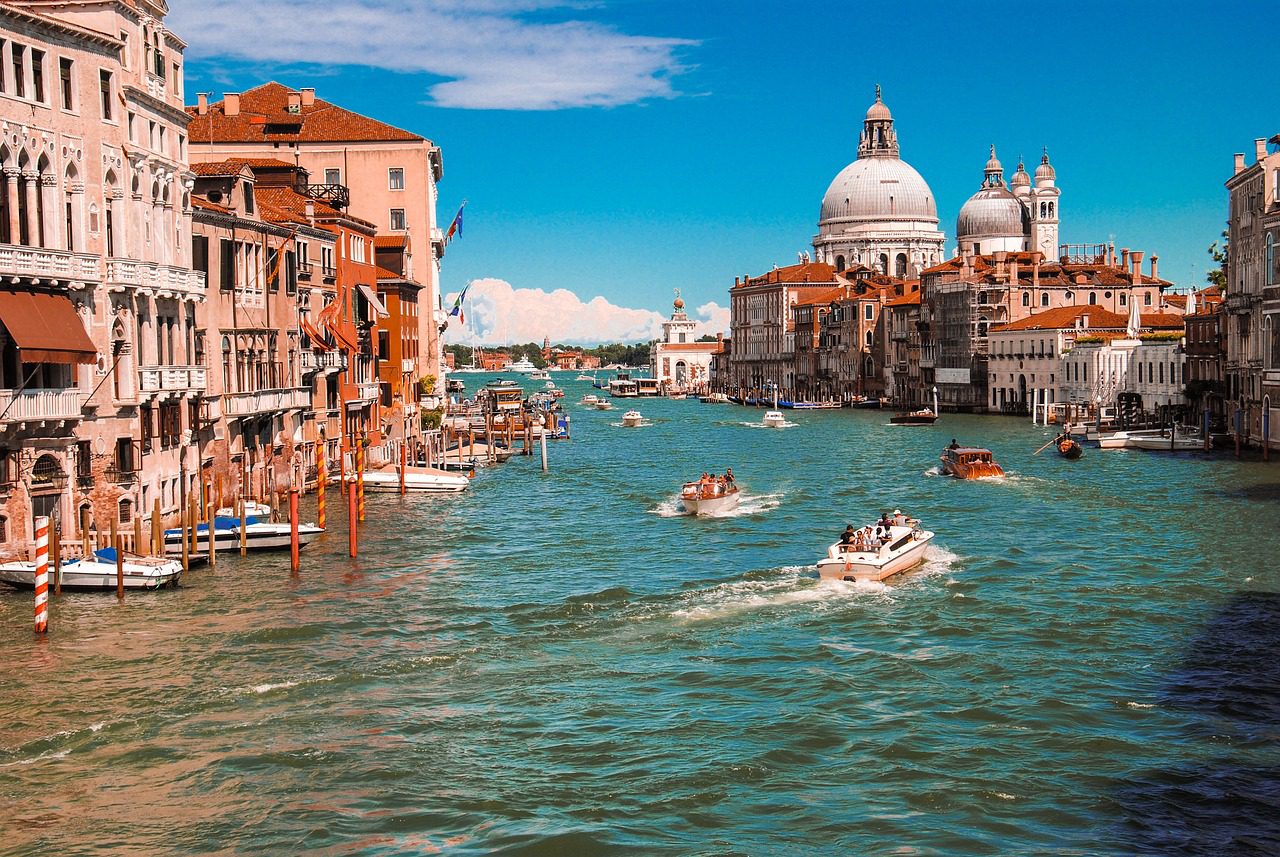 A group of boats floating down the water.