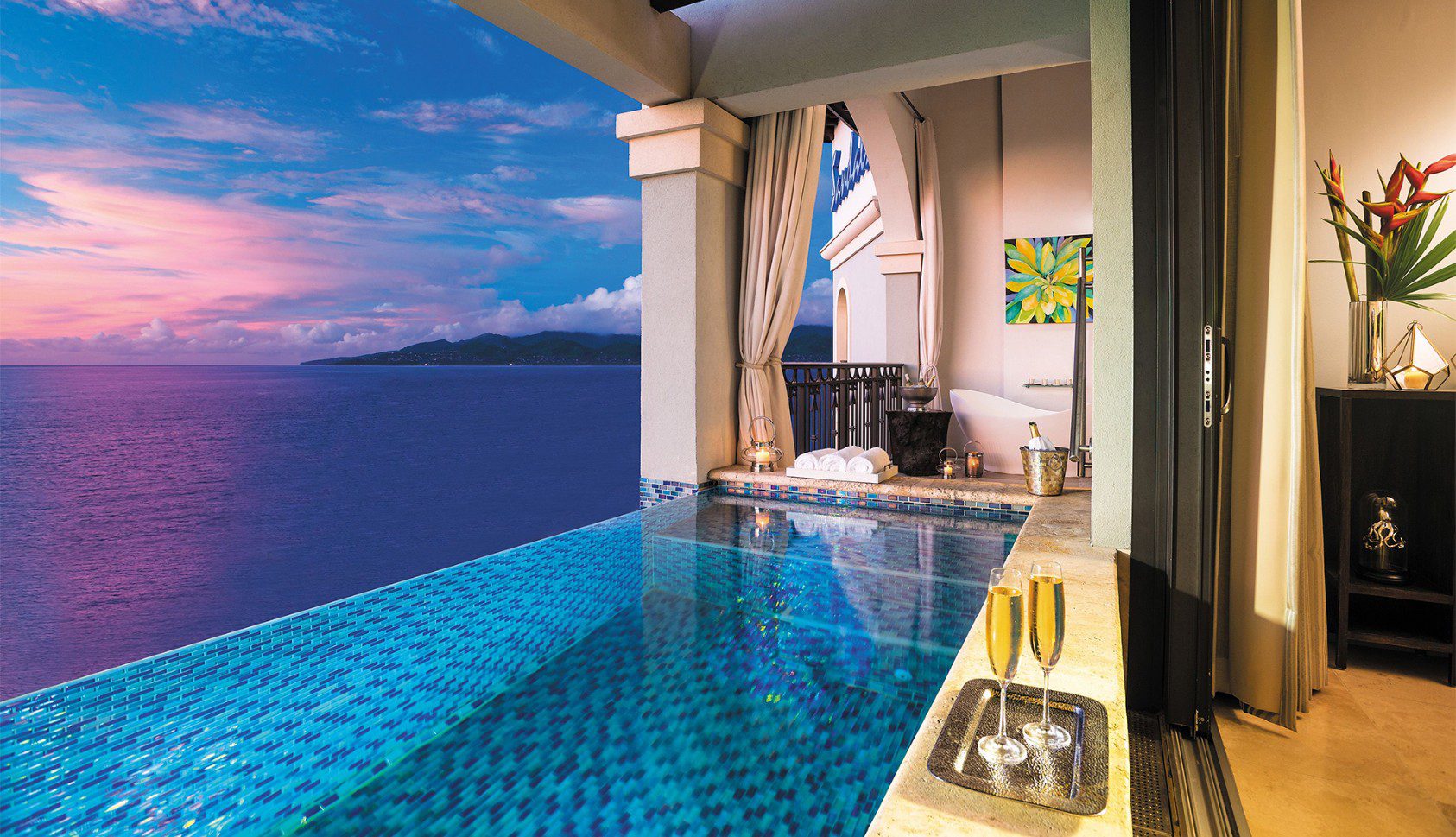 A pool with a view of the ocean and a balcony.