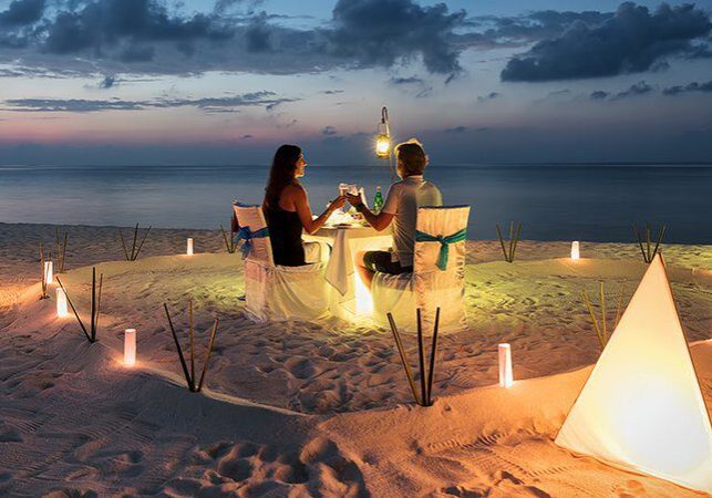 A couple of people sitting at the beach